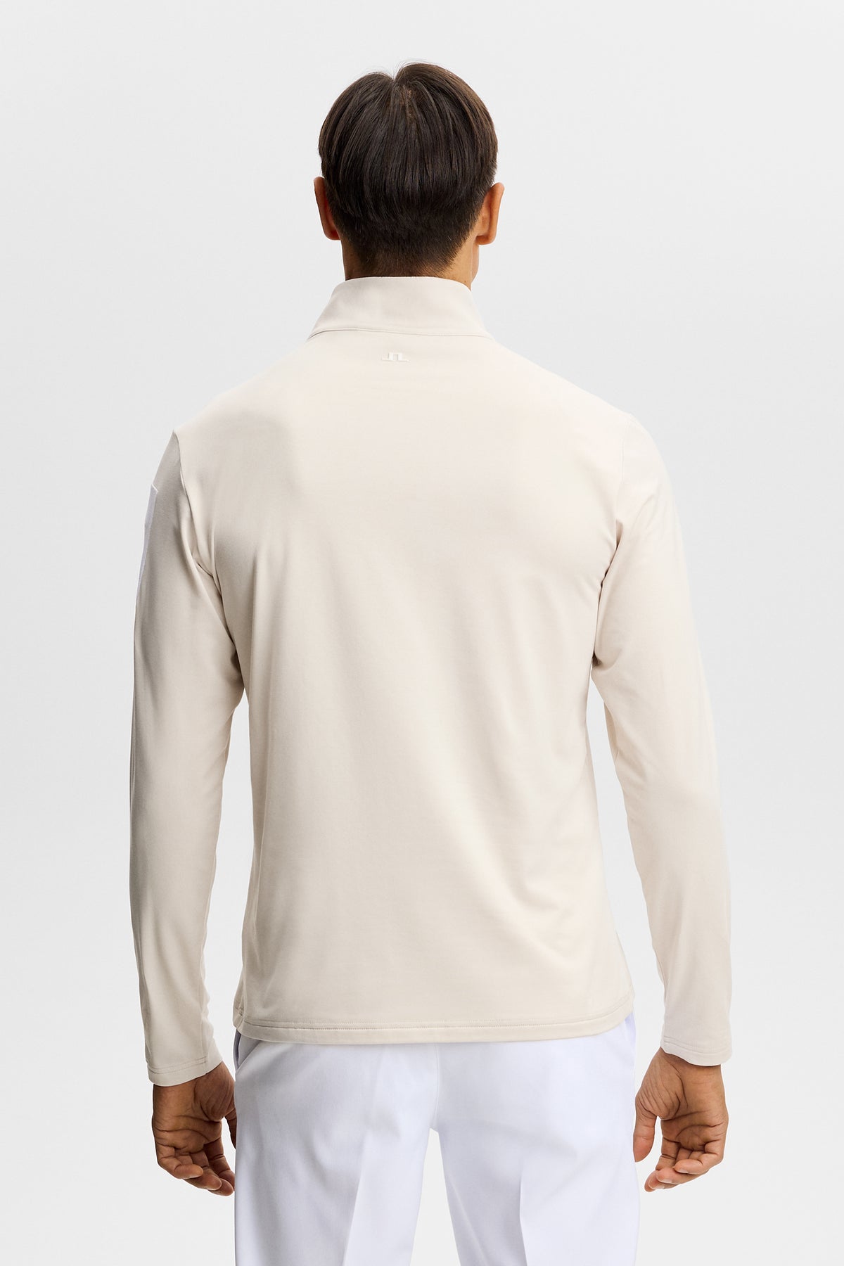 Střední vrstva J.Lindeberg Keaton Quarter Zip Moonbeam – detail gumového potisku na rukávu a částečného zipu