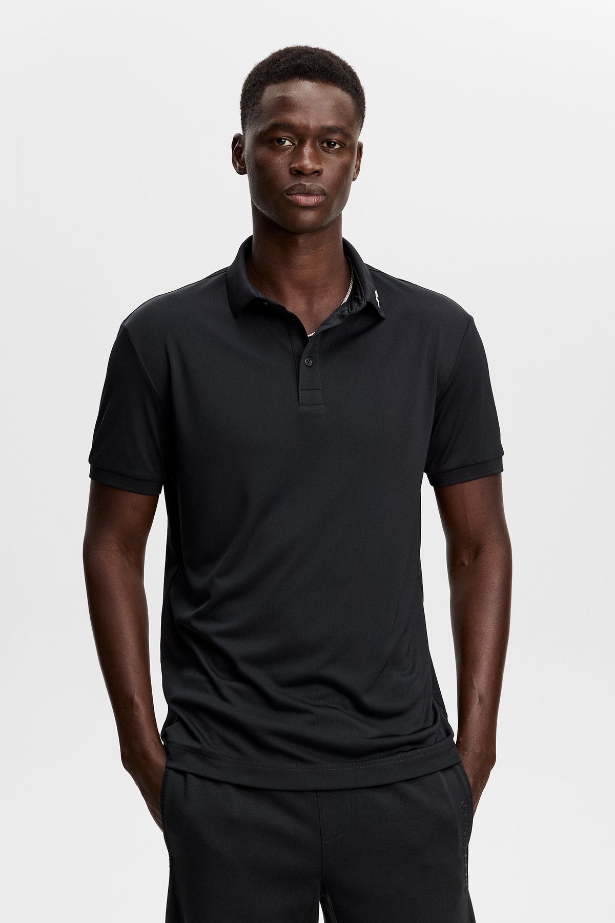 J.Lindeberg KV Print Polo Black – přední pohled ukazující žebrovaný límec a légu se třemi knoflíky